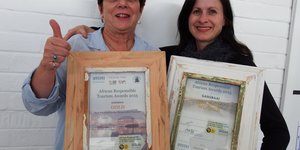 Links is Glenda Kitley (Bestuurder: Gansbaai Toerisme) met die Gansbaai Goud Sertifikaat saam met Brenda du Toit (Voorsitter: Gansbaai Toerisme) met die Gansbaai Algehele Wenner Sertifikaat